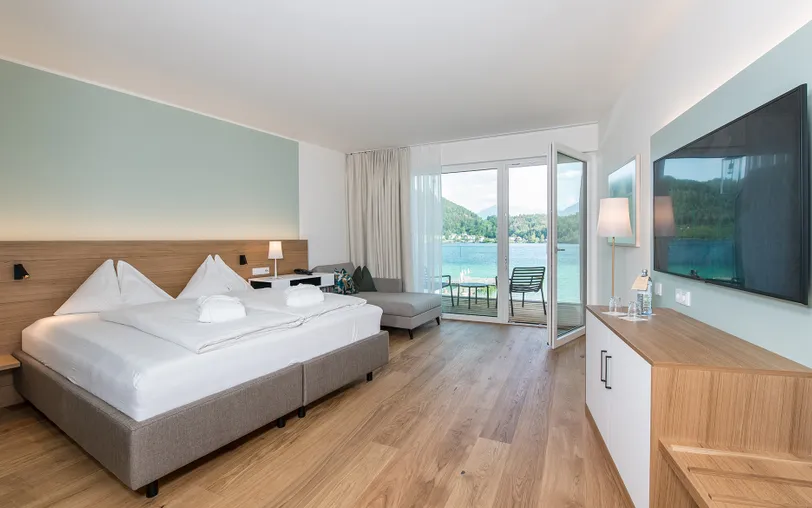 Doppelzimmer Morgentau Doppelbett vor türkiser Wand mit Blick auf Balkon